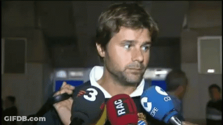 A Man Is Surrounded By Microphones Including One That Says Rac On It GIF