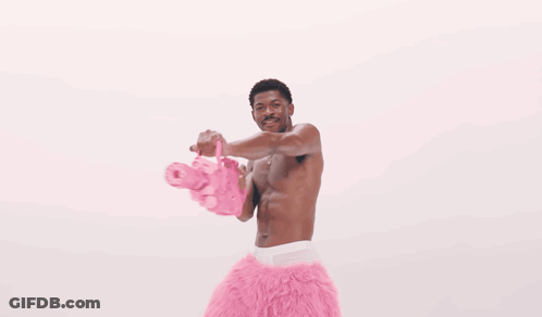 A Man Is Surrounded By Pink Hearts That Are Floating Around Him GIF