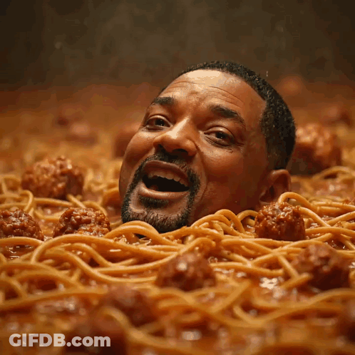 A Man Is Surrounded By Spaghetti And Meatballs GIF