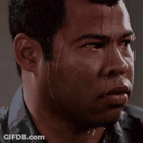 A Man Is Sweating Profusely And Looking At The Camera . GIF