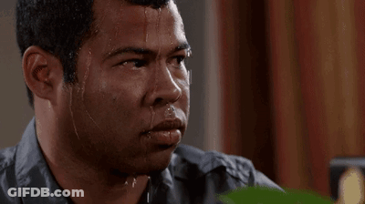 A Man Is Sweating Profusely And Looking At The Camera With Water Running Down His Face . GIF