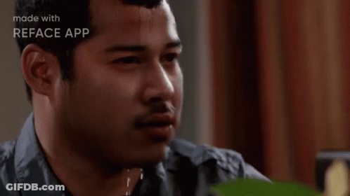 A Man Is Sweating While Sitting At A Table And Looking At The Camera . GIF