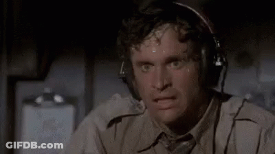 A Man Is Sweating While Wearing Headphones And Looking At The Camera . GIF