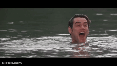 A Man Is Swimming In A Lake With His Mouth Open And His Eyes Closed . GIF