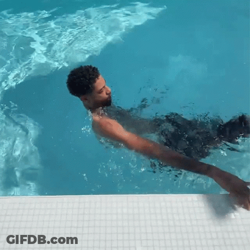A Man Is Swimming In A Pool With A White Tile Border GIF