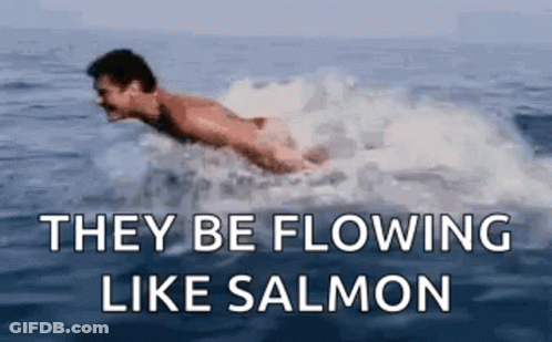 A Man Is Swimming In The Ocean With The Words `` They Be Flowing Like Salmon '' Below Him . GIF