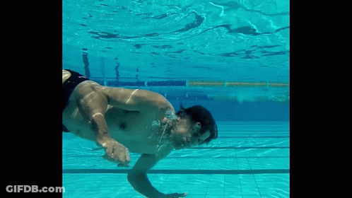 A Man Is Swimming Underwater In A Pool With His Mouth Open GIF