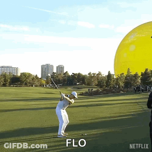 A Man Is Swinging A Golf Club On A Golf Course And The Word Flo Is Visible GIF