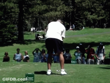 A Man Is Swinging A Golf Club On A Golf Course In Front Of A Green Sign That Says American Cancer Society GIF