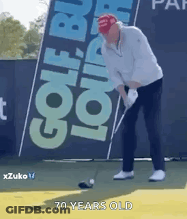 A Man Is Swinging A Golf Club On A Golf Course In Front Of A Sign That Says Golf . GIF