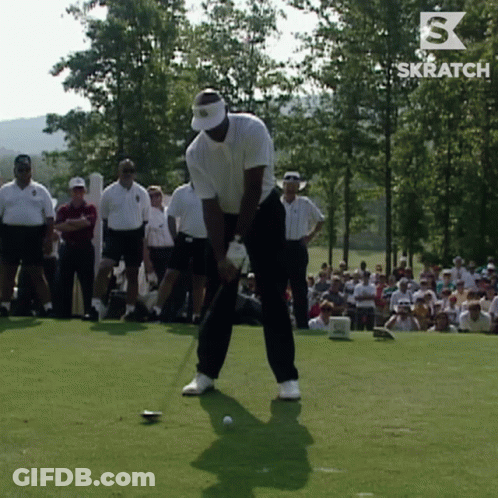 A Man Is Swinging A Golf Club On A Golf Course With A Skratch Logo Behind Him GIF
