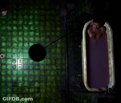 A Man Is Taking A Bath In A Bathtub With Purple Liquid GIF
