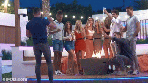 A Man Is Taking A Picture Of A Group Of People Holding Champagne Glasses GIF