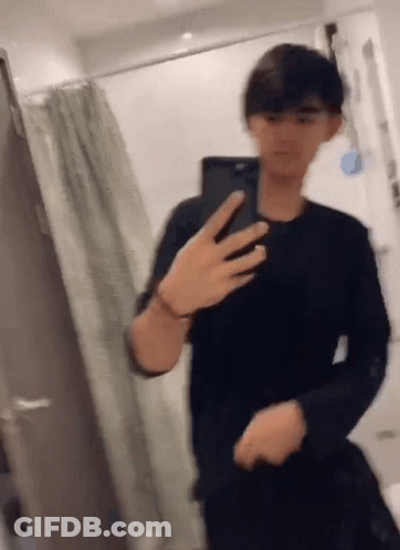 A Man Is Taking A Picture Of Himself In A Bathroom With His Phone . GIF