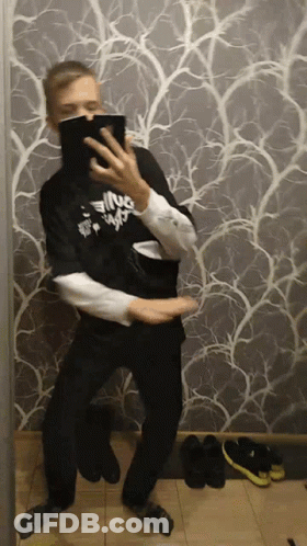 A Man Is Taking A Picture Of Himself In Front Of A Wall With A Pattern GIF