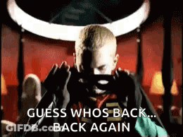 A Man Is Taking A Picture Of Himself With A Cell Phone And The Words `` Guess Who 'S Back ... Back Again '' . GIF