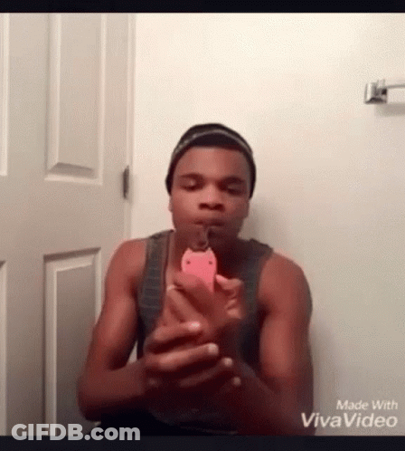 A Man Is Taking A Picture Of Himself With A Cell Phone . GIF