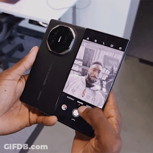 A Man Is Taking A Picture Of Himself With A Phone That Says Huawei On It GIF