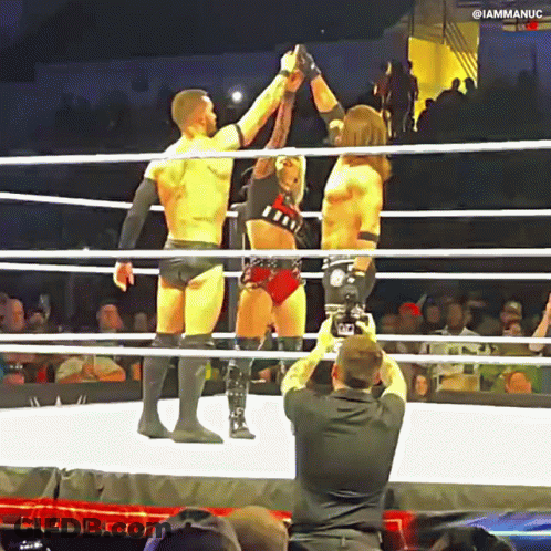 A Man Is Taking A Picture Of Two Wrestlers In The Ring GIF