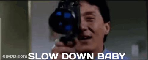 A Man Is Taking A Picture With A Camera And The Words Slow Down Baby Are Below Him GIF
