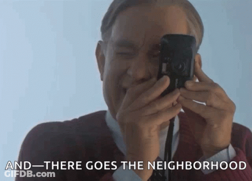 A Man Is Taking A Picture With The Words " And There Goes The Neighborhood " Behind Him GIF