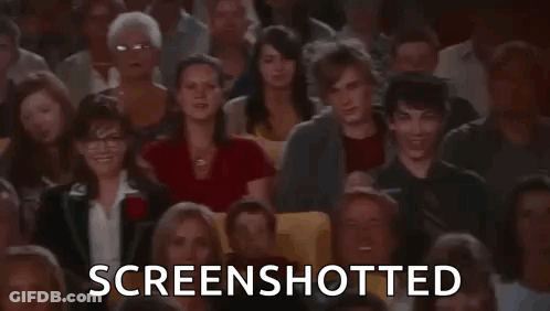 A Man Is Taking A Screenshot Of A Crowd Of People In A Theatre . GIF