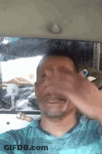 A Man Is Taking A Selfie In A Car . GIF