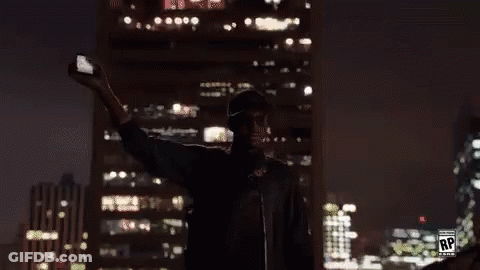 A Man Is Taking A Selfie In Front Of A Large Screen With The Letters Rp On It GIF