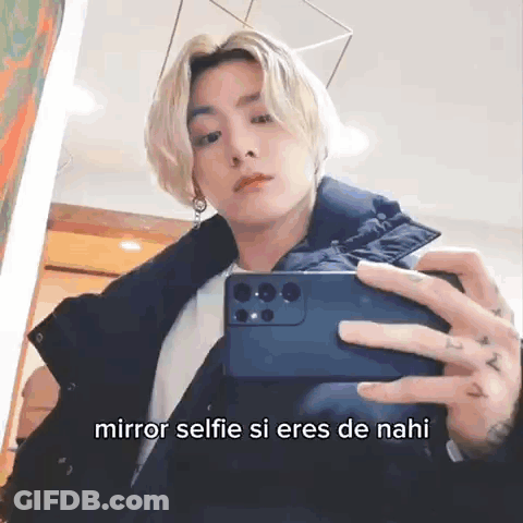 A Man Is Taking A Selfie In Front Of A Mirror With A Caption . GIF