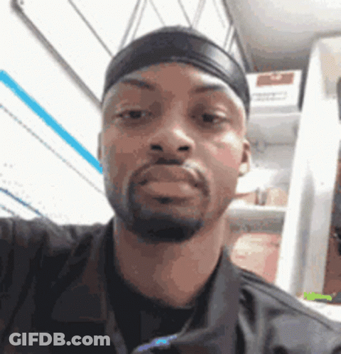 A Man Is Taking A Selfie In Front Of A Refrigerator . GIF