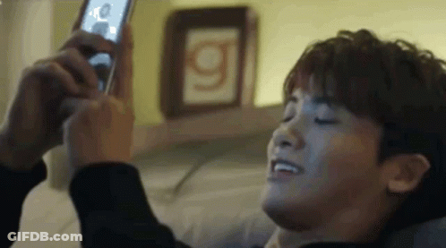 A Man Is Taking A Selfie With A Cell Phone . GIF