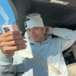 A Man Is Taking A Selfie With A Pink Phone GIF