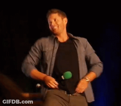 A Man Is Taking Off His Shirt On A Stage And Dancing . GIF