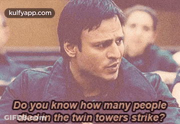 A Man Is Talking About How Many People Died In A Twin Towers Strike . GIF