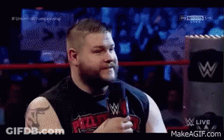 A Man Is Talking Into A Microphone In A Wrestling Ring GIF
