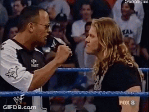 A Man Is Talking Into A Microphone In A Wrestling Ring . GIF