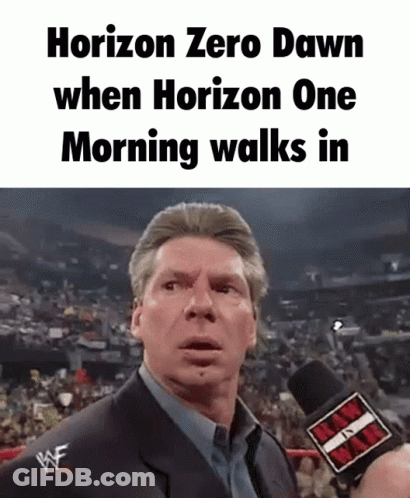A Man Is Talking Into A Microphone In Front Of A Crowd . GIF