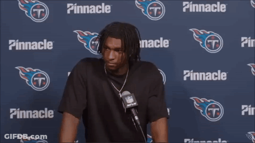 A Man Is Talking Into A Microphone In Front Of A Pinnacle Banner GIF