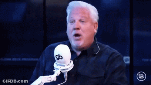 A Man Is Talking Into A Microphone With The Words Doinks Written In Front Of Him GIF