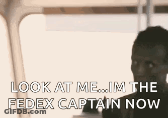 A Man Is Talking On A Cell Phone And Looking At The Fedex Captain Now . GIF