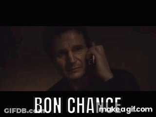A Man Is Talking On A Cell Phone In A Dark Room With The Words Bon Chance Written On The Bottom . GIF