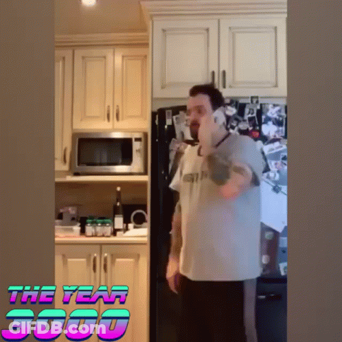 A Man Is Talking On A Cell Phone In A Kitchen With The Year 3000 On The Bottom GIF