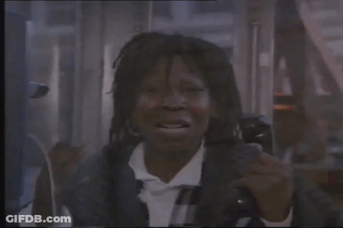 A Man Is Talking On A Cell Phone In A Phone Booth . GIF