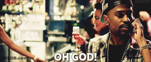 A Man Is Talking On A Cell Phone While Holding A Glass Of Wine And Saying " Oh God " GIF