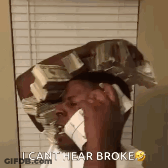 A Man Is Talking On A Cell Phone While Holding A Stack Of Money On His Head . GIF