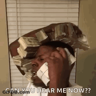 A Man Is Talking On A Cell Phone While Holding A Stack Of Money On His Head . GIF