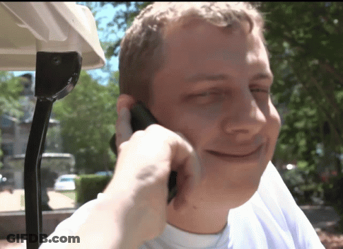 A Man Is Talking On A Cell Phone While Sitting In A Golf Cart GIF