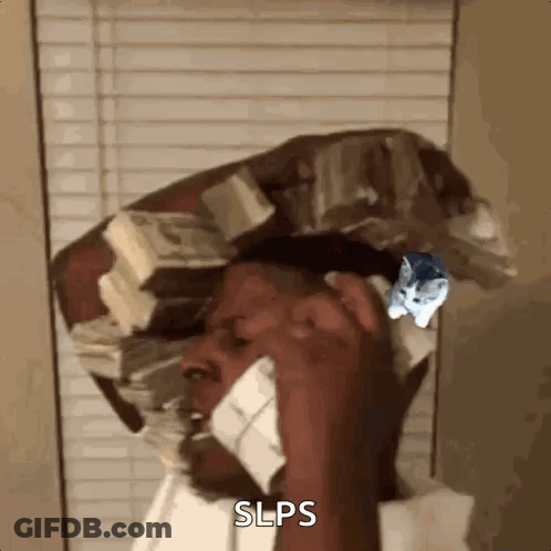 A Man Is Talking On A Cell Phone While Wearing A Hat Made Of Money . GIF