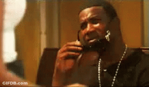 A Man Is Talking On A Cell Phone While Wearing A Necklace . GIF