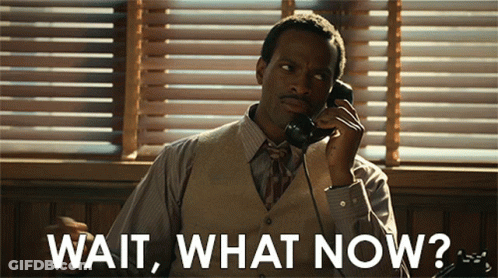A Man Is Talking On A Phone With The Words Wait What Now Written Below Him GIF